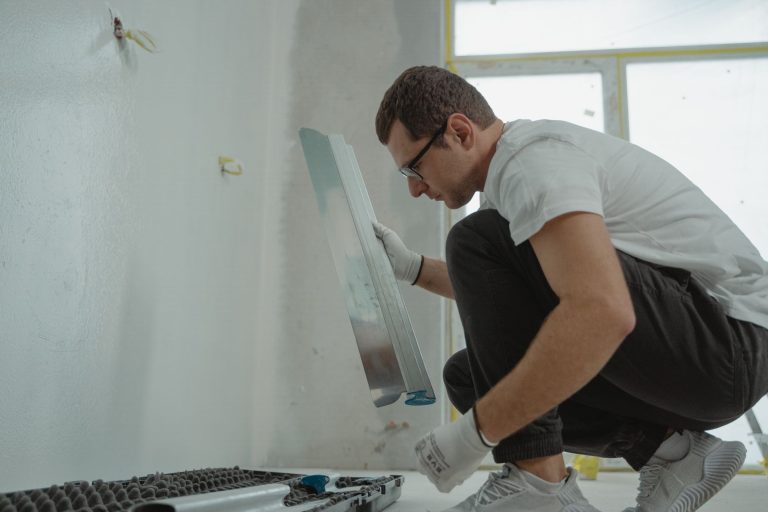 Декоративна штукатурка: ціна за роботу в 2026 році Майстер вирівнює стіну перед нанесенням декоративної штукатурки